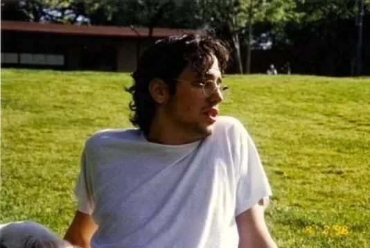 Ariel Weissmann sitting on a lawn on a sunny day.